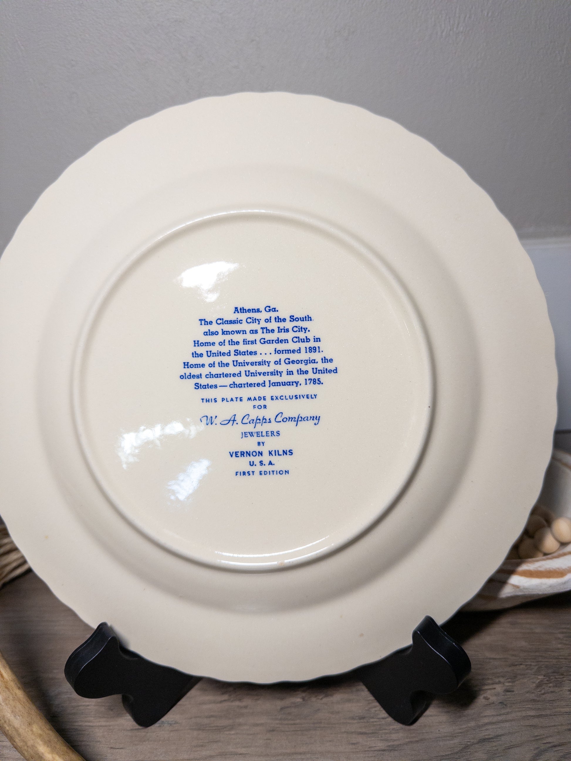 Vintage Athens Georgia souvenir plate by Vernon Kilns featuring University of Georgia imagery, displayed on a wooden surface.