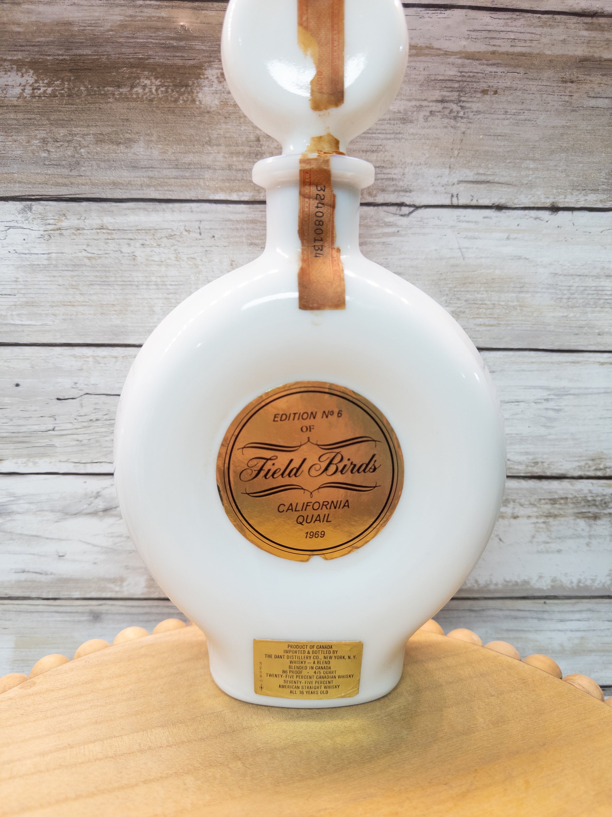 Vintage 1969 Wild Feathered Finds California Quail whiskey decanter made of milk glass, featuring a detailed bird design.