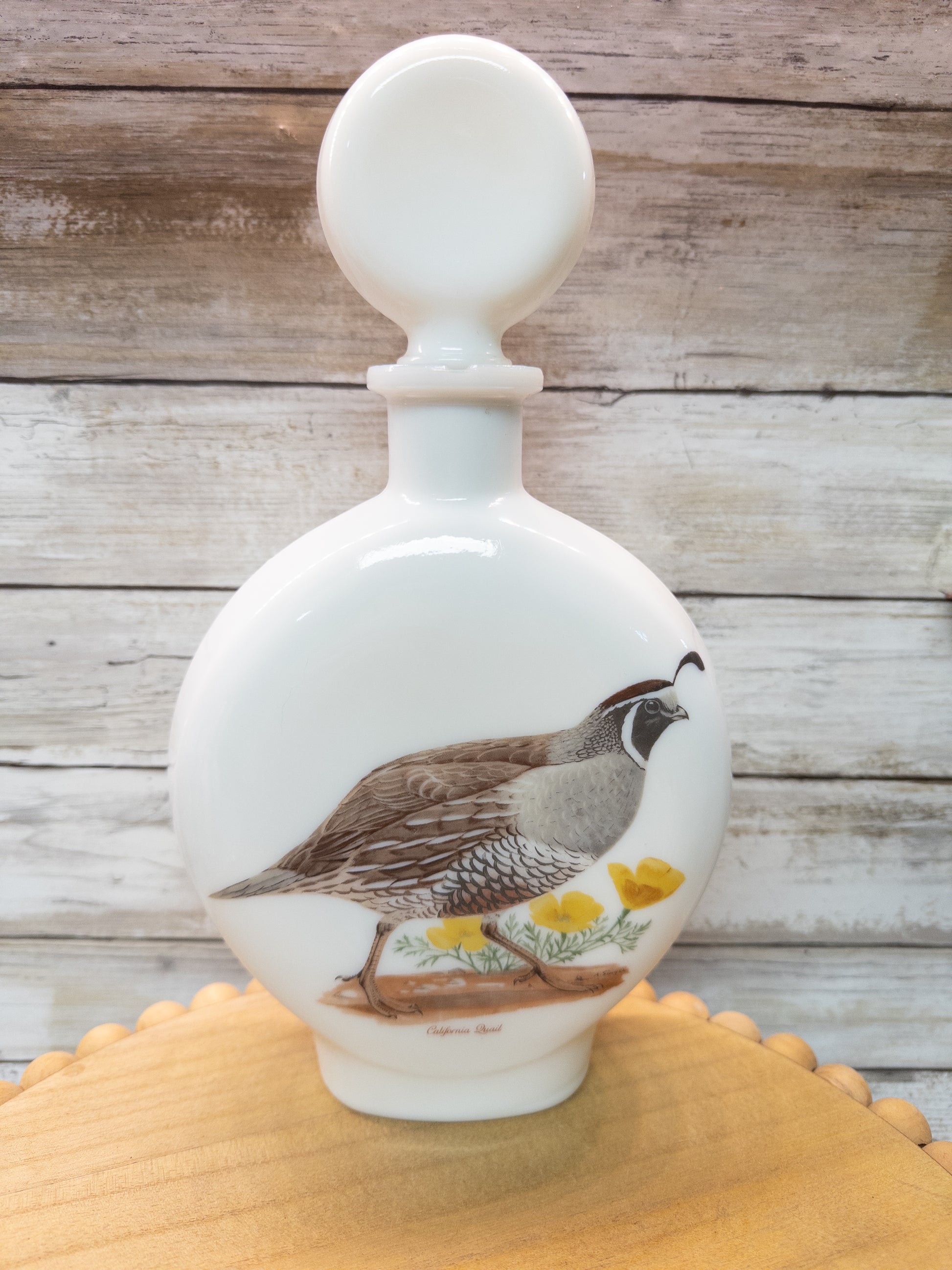 Vintage 1969 Wild Feathered Finds California Quail whiskey decanter in milk glass, featuring a detailed bird design from Dant Distillery.