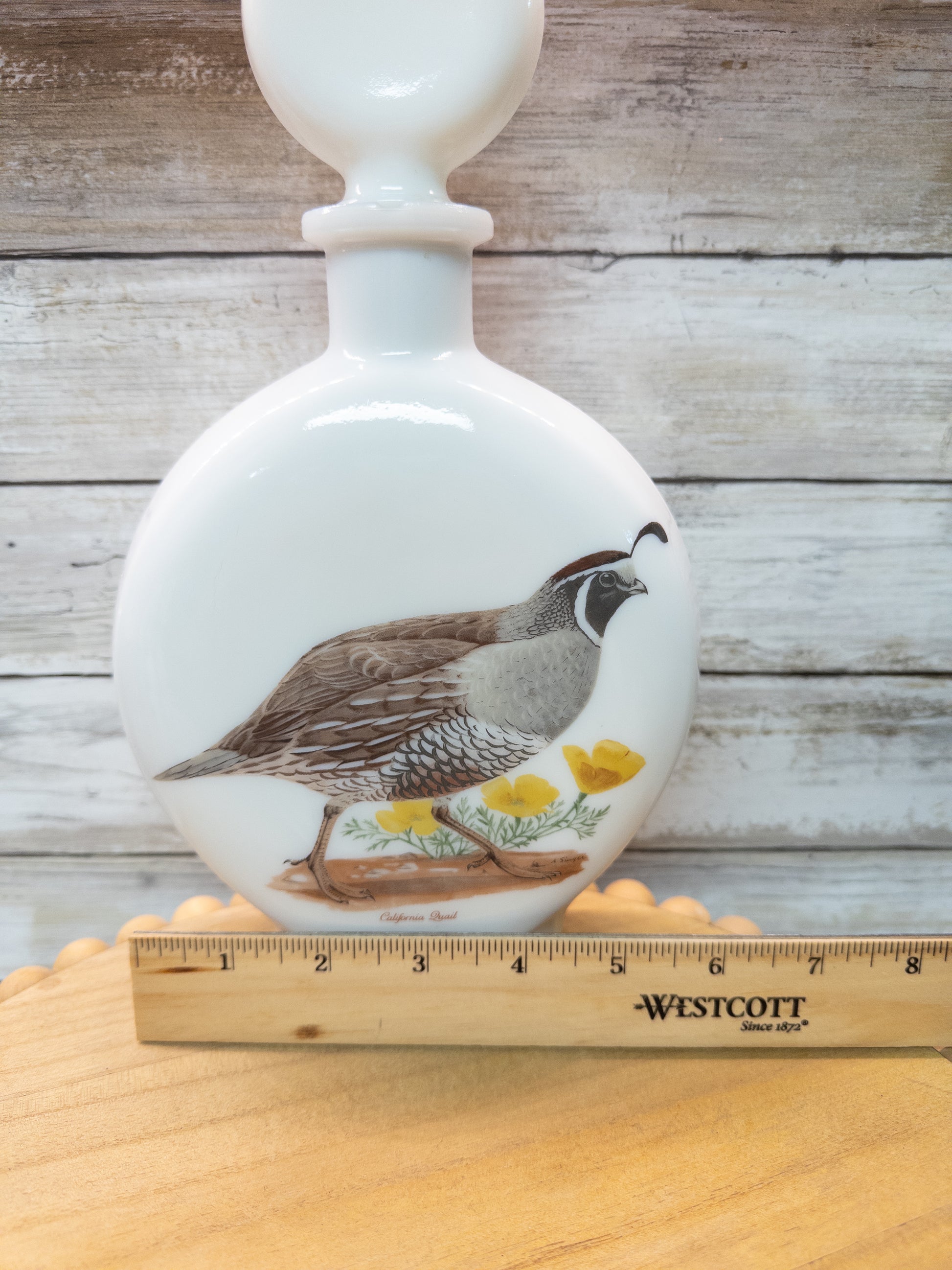 Vintage 1969 Wild Feathered Finds California Quail whiskey decanter in milk glass, featuring detailed bird design from Dant Distillery.