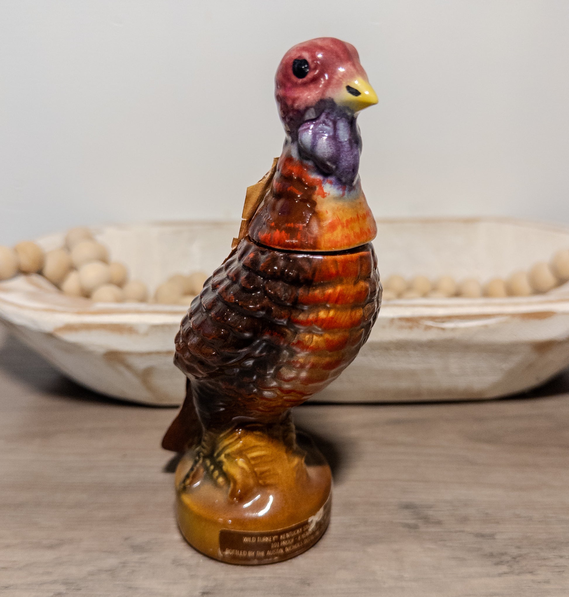 Vintage Wild Turkey ceramic decanter displaying a 1970s bourbon bottle with Wild Feathered Finds branding and detailed ceramic design.