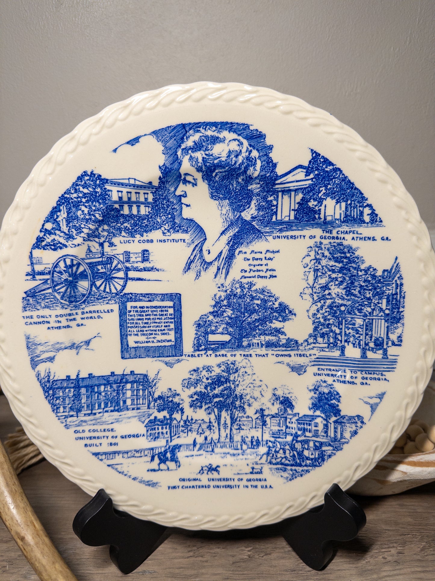 Vintage Athens Georgia souvenir plate by Vernon Kilns featuring University of Georgia imagery, displayed on a wooden surface.