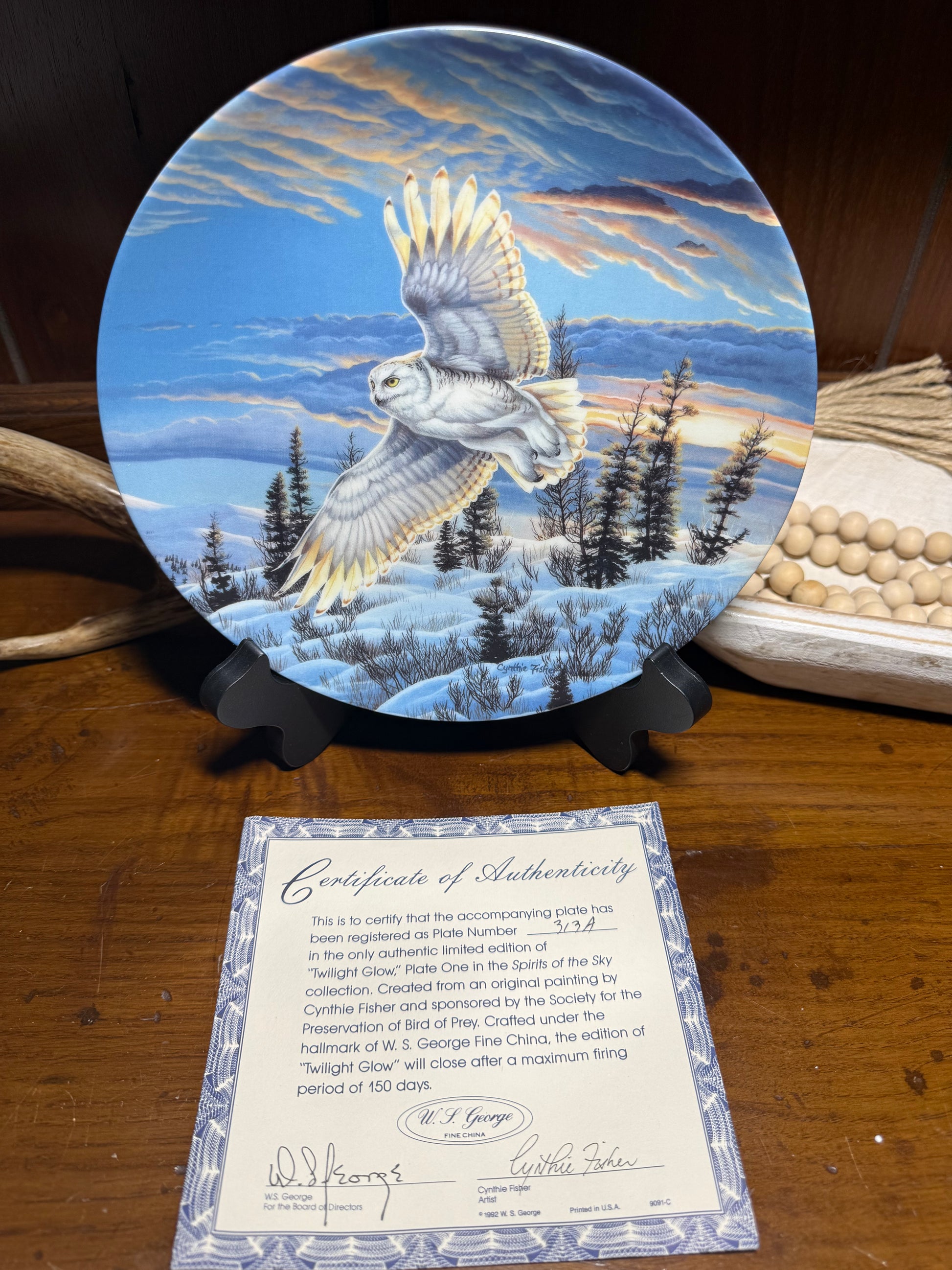 "Wild Feathered Finds Twilight Glow Snowy Owl collector plate by Cynthie Fisher, featuring snowy owl design and certificate of authenticity."